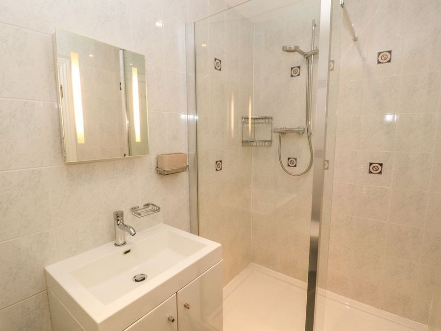 A bathroom with a sink vanity unit and a shower area at Roger Pot Garsdale near Sedbergh