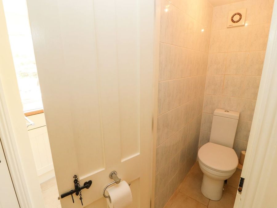 A small bathroom with a toilet and tiled walls at Roger Pot in Garsdale near Sedbergh