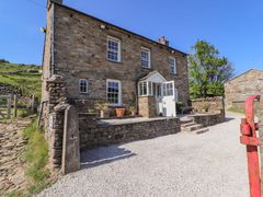 A stone house with a porch and gravel driveway at Roger Pot in Garsdale near Sedbergh