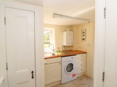 A utility room with a washing machine sink and countertop at Roger Pot in Garsdale near Sedbergh