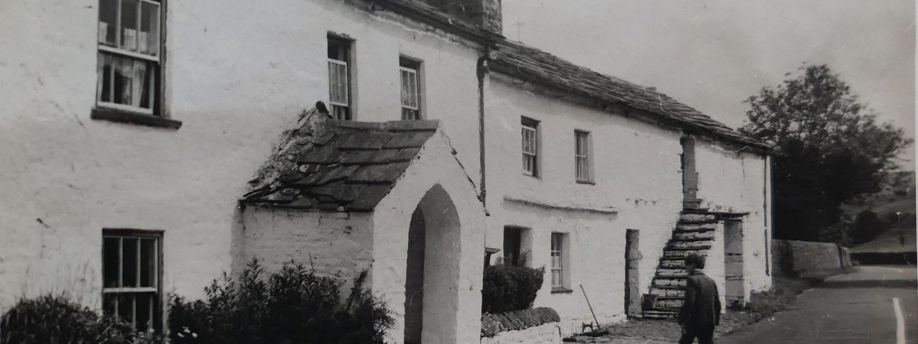 Historic white cottages beside a lane in Garsdale