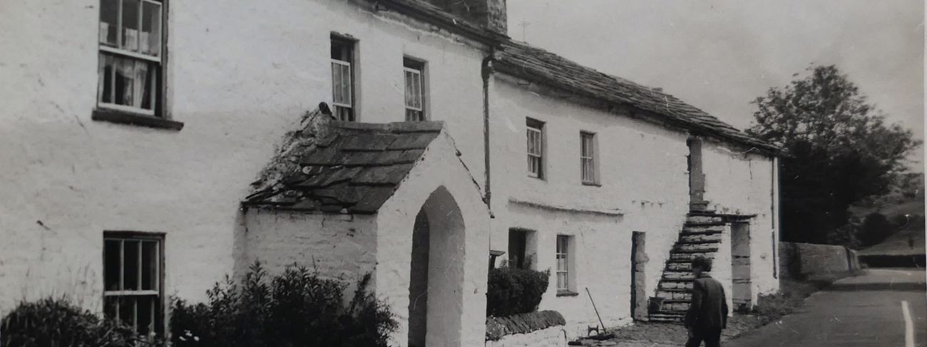 Historic white cottages beside a lane in Garsdale