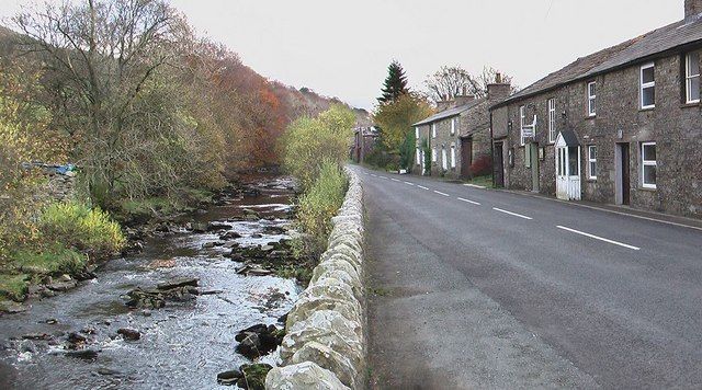 The Clough River running beside stone buildings in Garsdale
