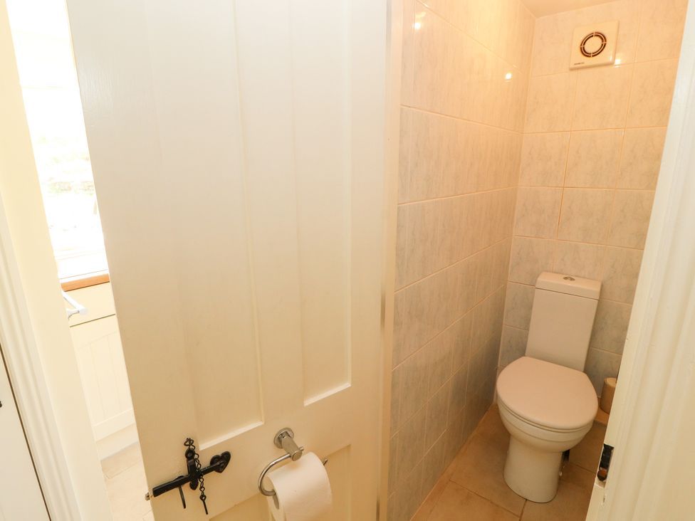 A small bathroom with a toilet and tiled walls at Roger Pot in Garsdale near Sedbergh