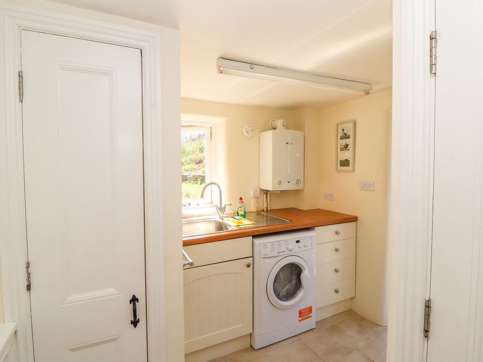 A utility room with a washing machine sink and countertop at Roger Pot in Garsdale near Sedbergh