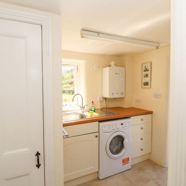 The Roger Pot utility room with a washing machine, stainless-steel sink and wall-mounted boiler