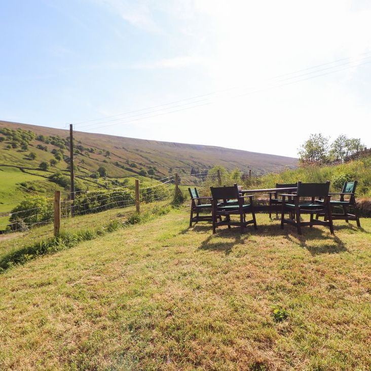 An outdoor dining set on the lawn at Roger Pot overlooking rolling green hills