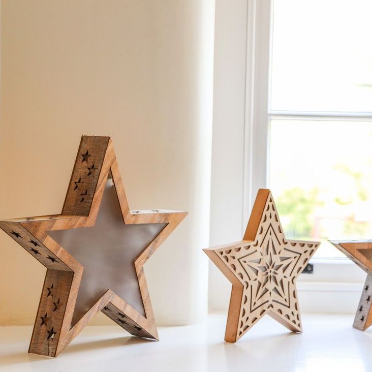 Three wooden star-shaped ornaments on a sunlit windowsill at Roger Pot