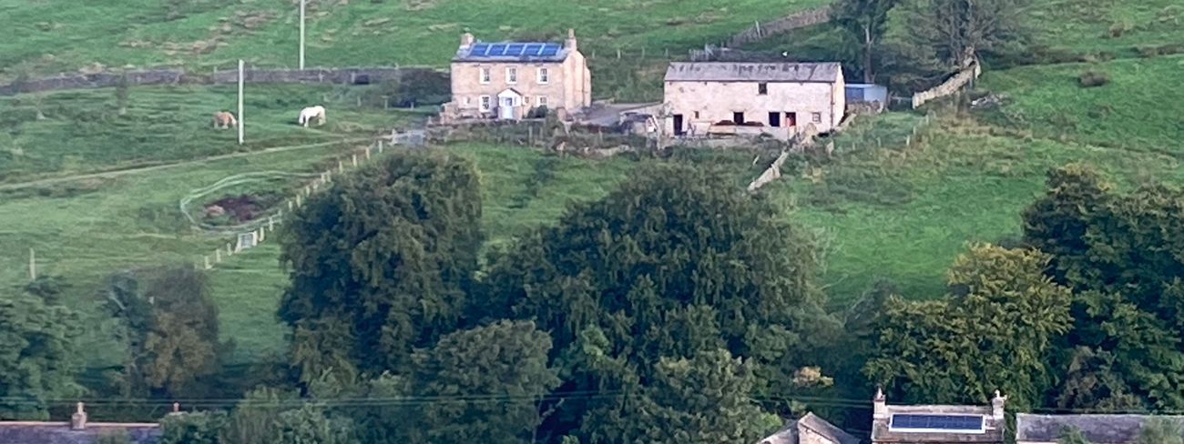 View across Garsdale with stone cottages and green hills