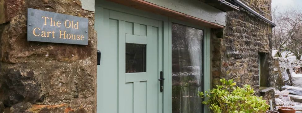The Old Cart House exterior with green door